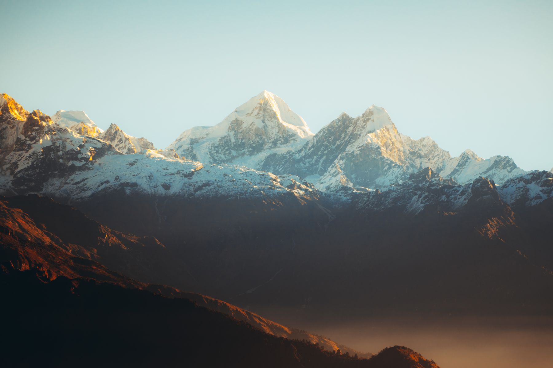 The three snow-clad Himalayan peaks at golden hour — the view from Trimounts
